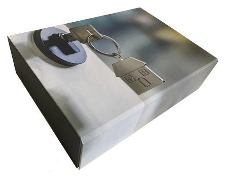 Une boîte format A4 recouverte d'une personnalisation pour architecte représentant une serrure avec une clé dedans et le porte clé est en forme de petite maison